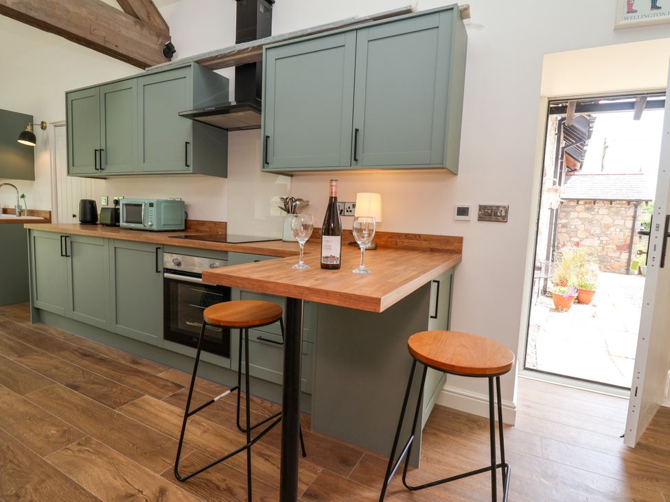 A kitchen with cabinets and a countertop at The Barn in Tafarn-Y-Gelyn