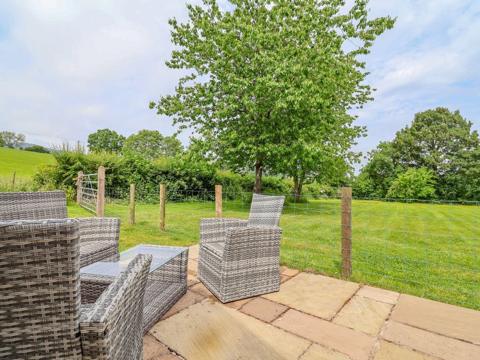An outdoor seating area with chairs and a table at The Barn Tafarn-Y-Gelyn