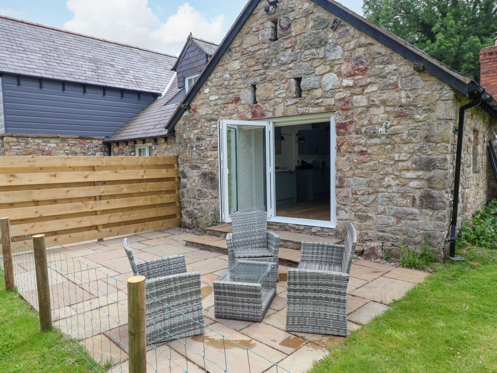 An outdoor seating area with chairs and table at The Barn in Tafarn-Y-Gelyn