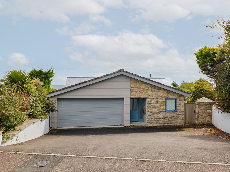 A house with a garage and driveway at 13 Downside Close in Charmouth