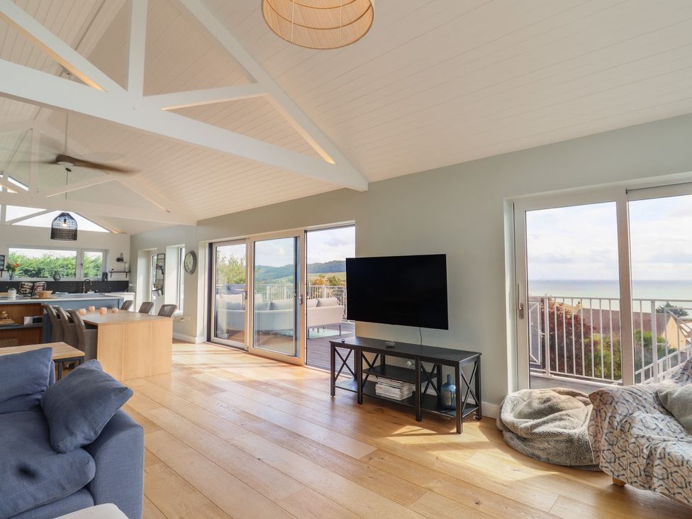 A living room with a television and sofa at 13 Downside Close in Charmouth