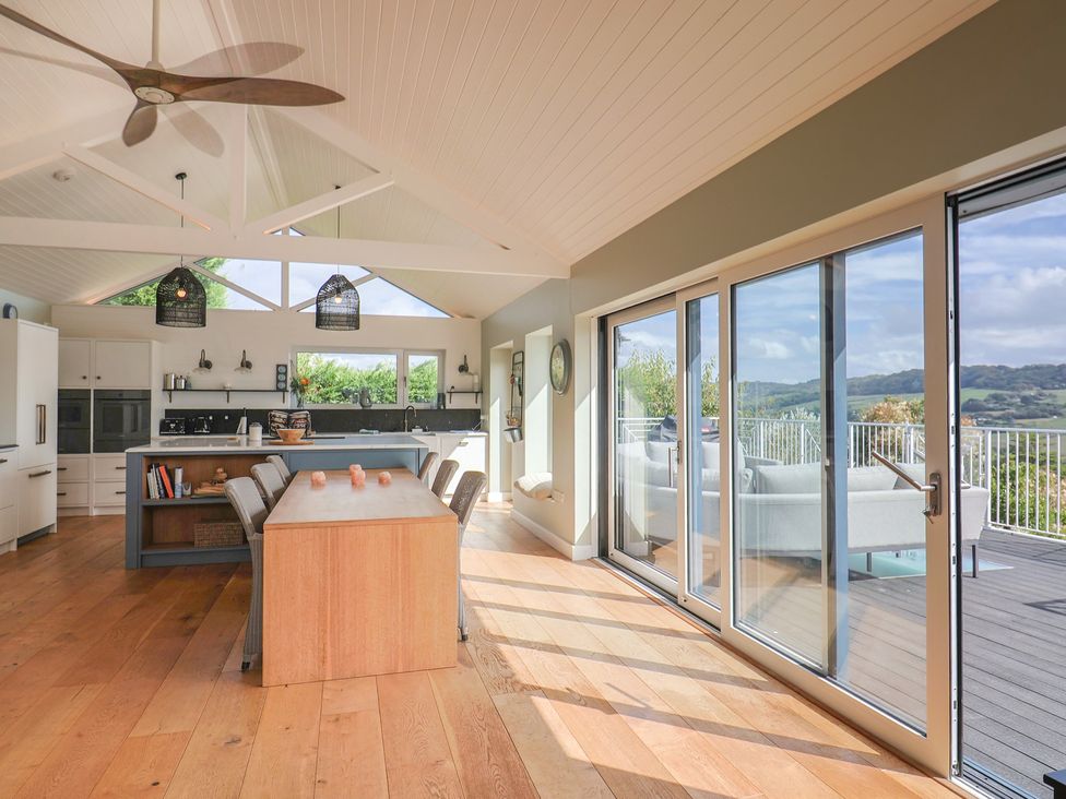 A kitchen with an island and barstools at 13 Downside Close Charmouth