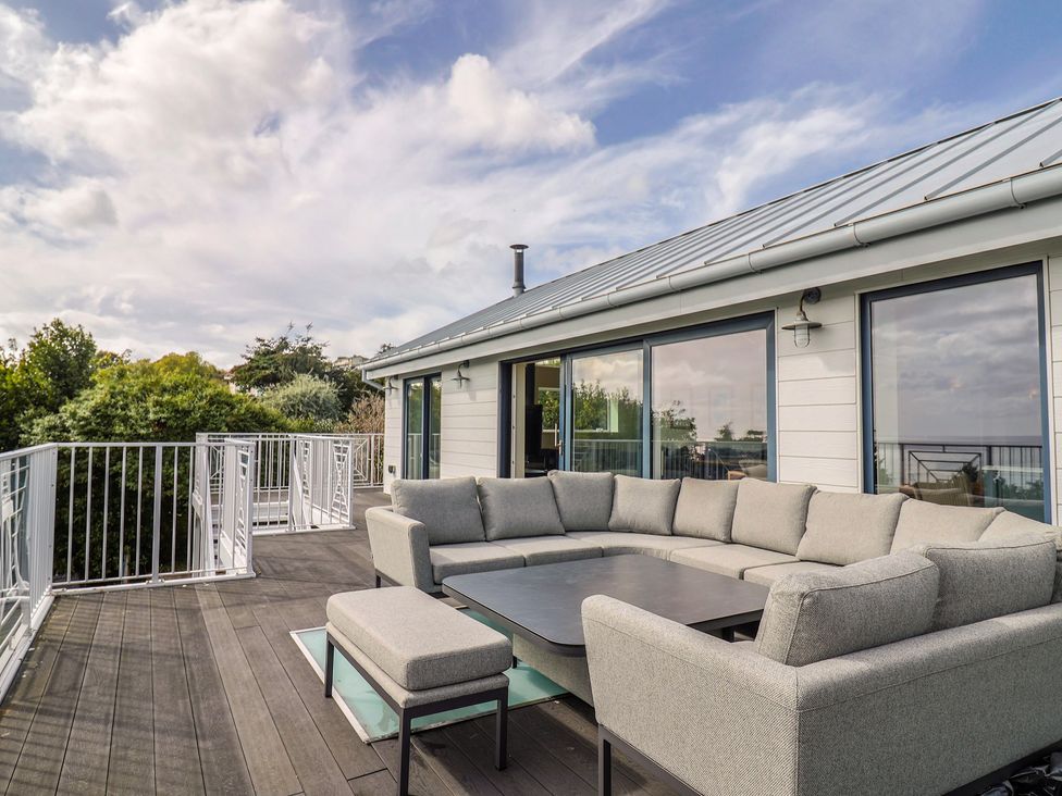 An outdoor living area with a sofa and coffee table at 13 Downside Close in Charmouth