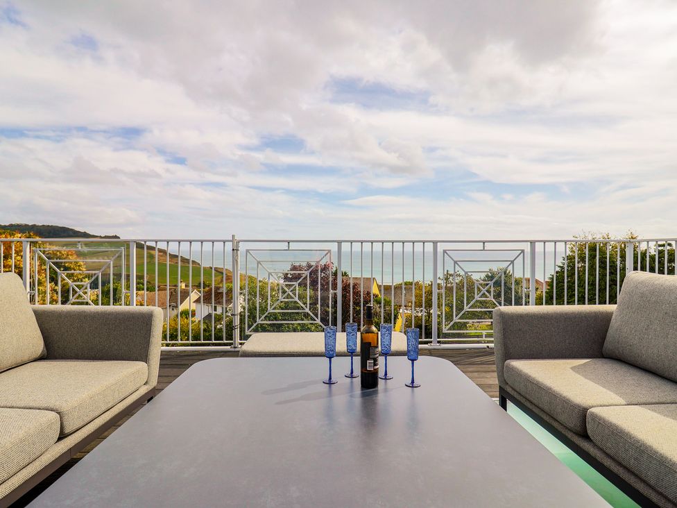 An outdoor seating area with sofas and a table at 13 Downside Close in Charmouth