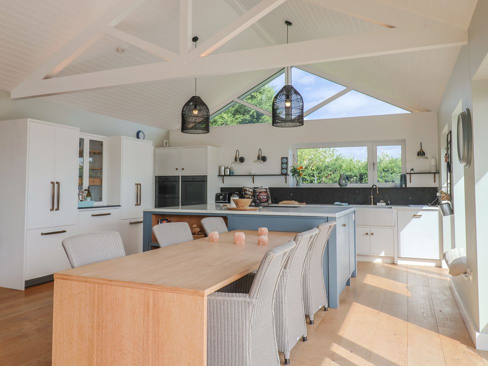A kitchen with a dining table and chairs at 13 Downside Close in Charmouth