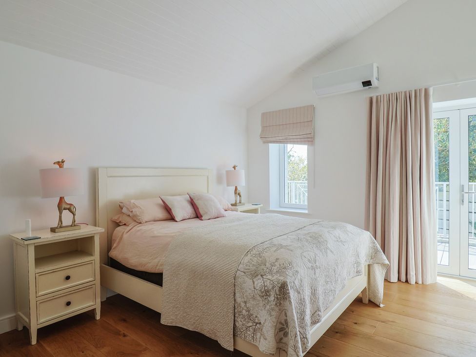 A bedroom with a bed and nightstands at 13 Downside Close Charmouth