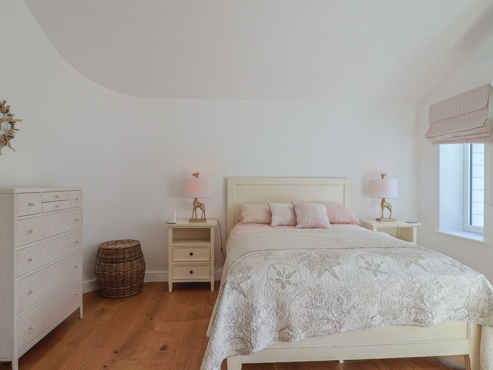 A bedroom with a bed, nightstands, and a dresser at 13 Downside Close in Charmouth