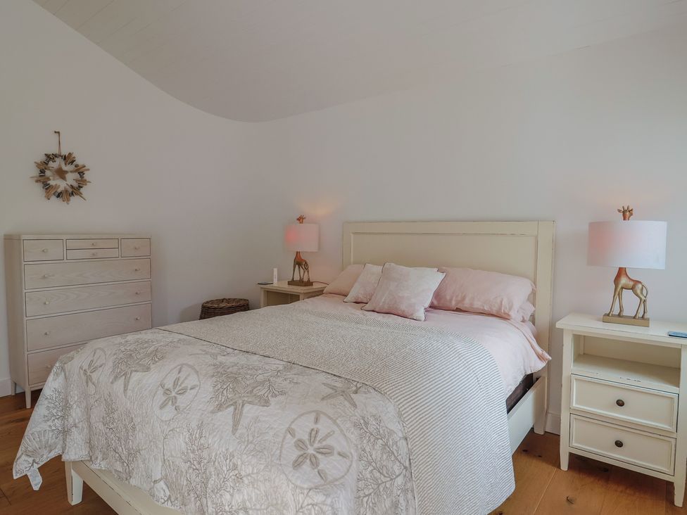 A bedroom with a bed and nightstands at 13 Downside Close Charmouth