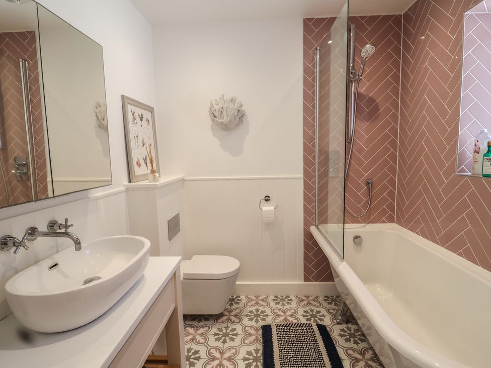 A bathroom with sink, toilet, shower, and bathtub at 13 Downside Close Charmouth