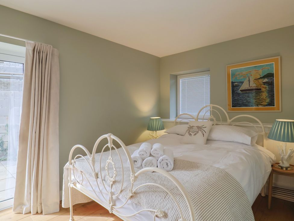 A bedroom with a bed and artwork at 13 Downside Close, Charmouth