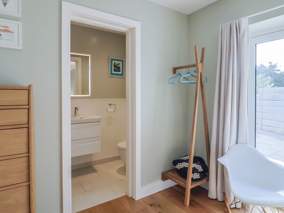 A bedroom with a view into a bathroom at 13 Downside Close Charmouth