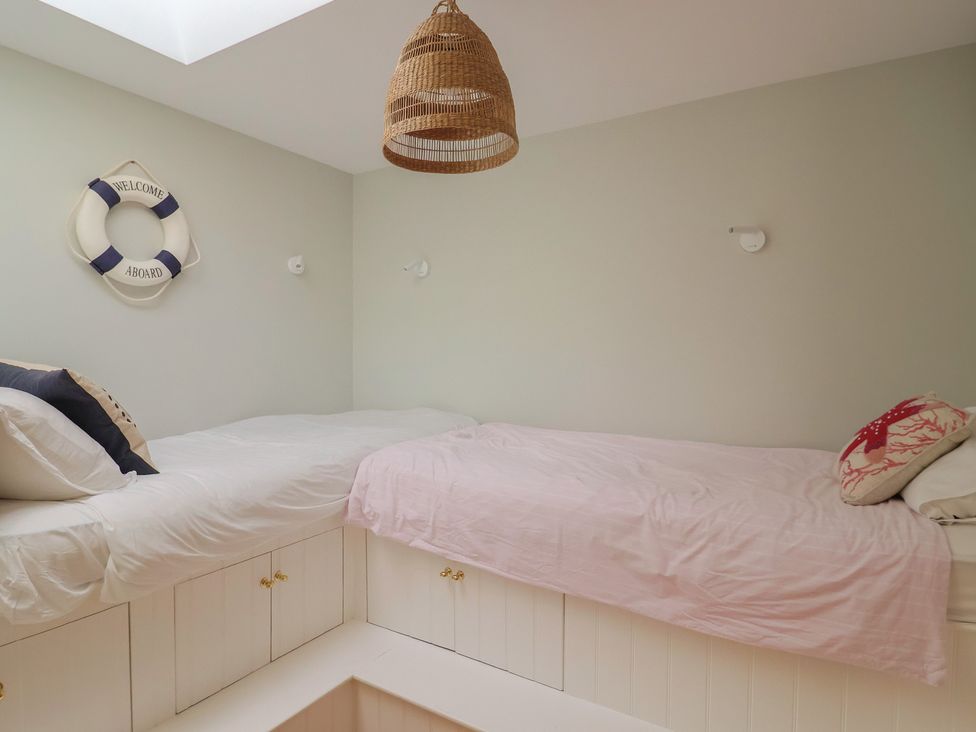 A bedroom with two beds and a life preserver at 13 Downside Close Charmouth