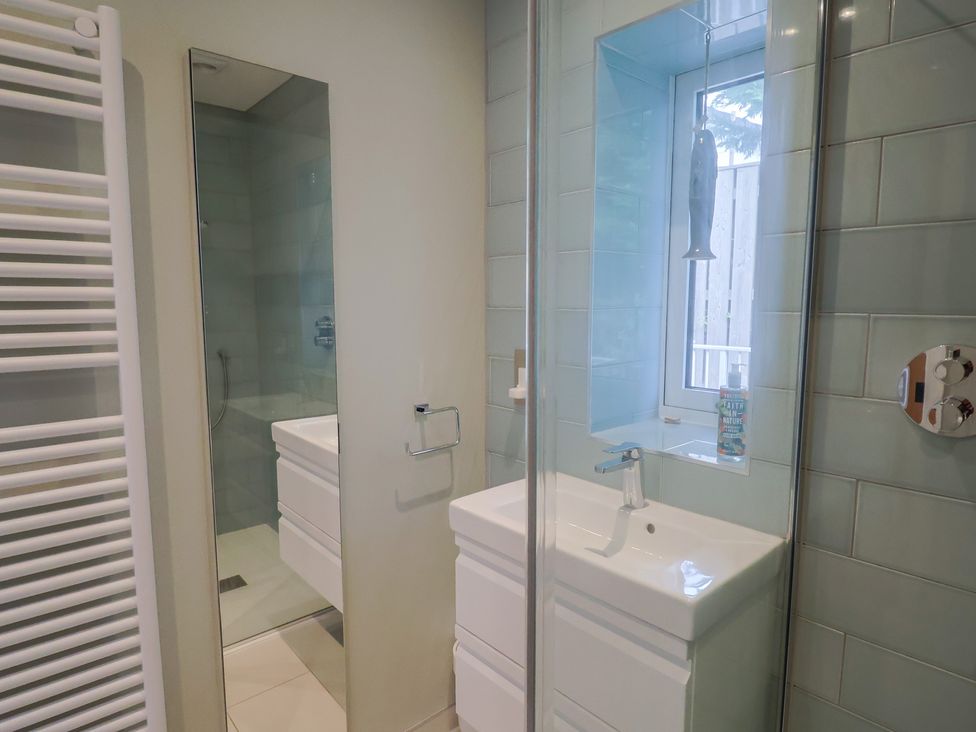 A bathroom with a shower and sink at 13 Downside Close, Charmouth