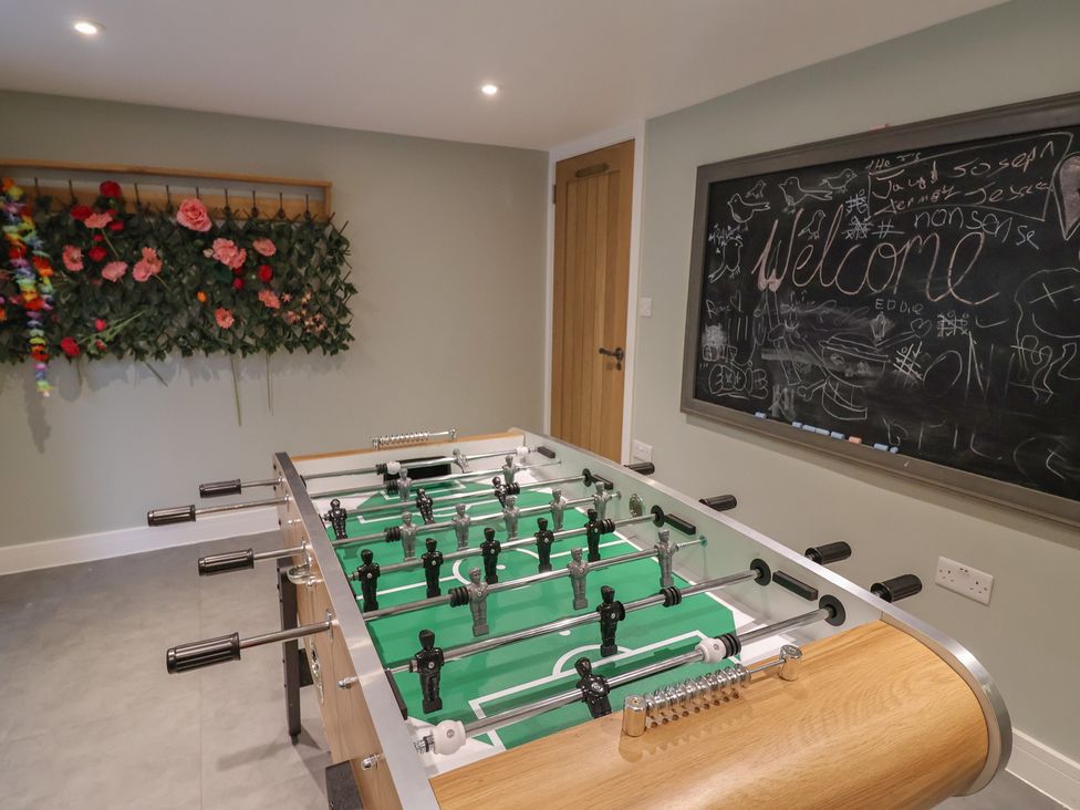A recreation room with a foosball table and chalkboard at 13 Downside Close, Charmouth