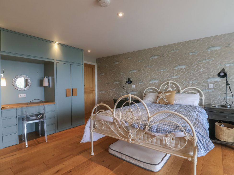 A bedroom with a bed, desk, and chair at 13 Downside Close in Charmouth