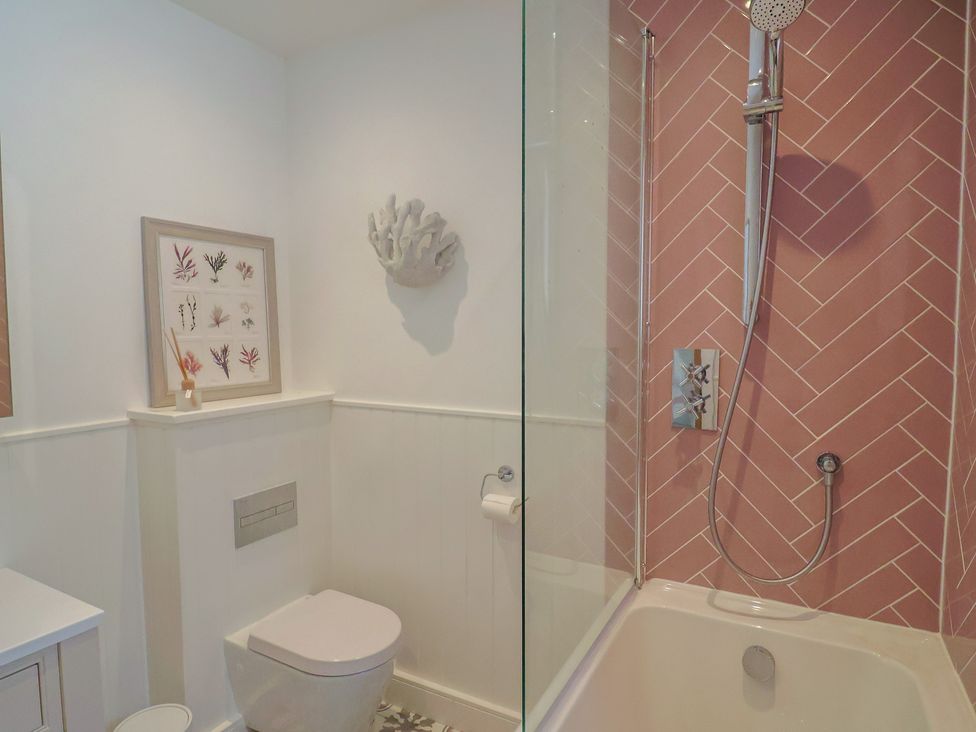 A bathroom with a shower and a toilet at 13 Downside Close in Charmouth