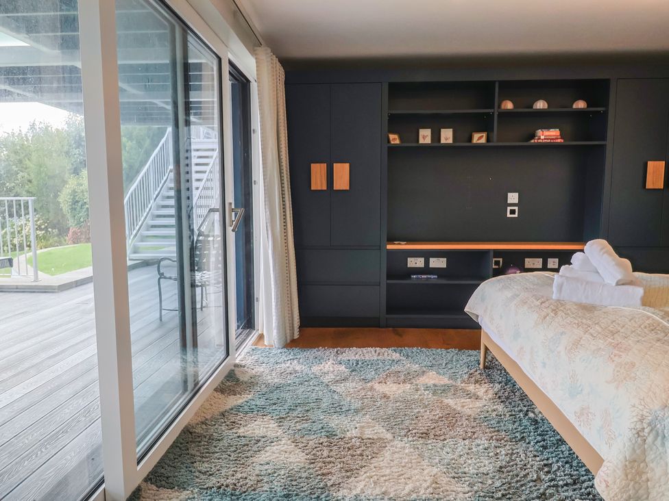 A bedroom with a bed and a bookshelf at 13 Downside Close in Charmouth