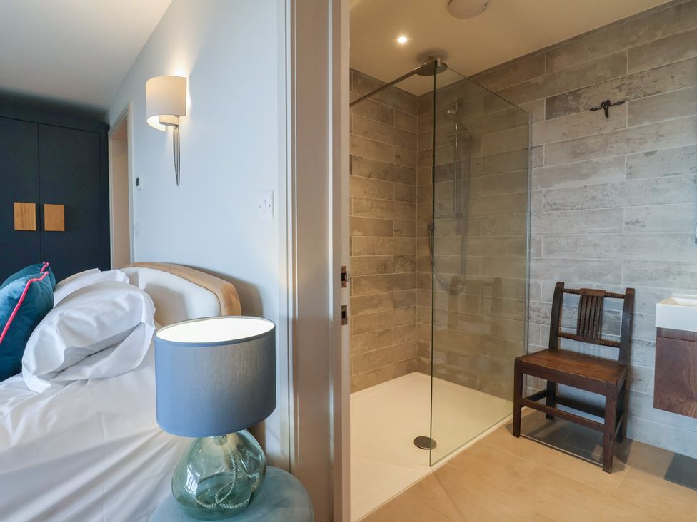 A bedroom with a bed and a shower area at 13 Downside Close in Charmouth
