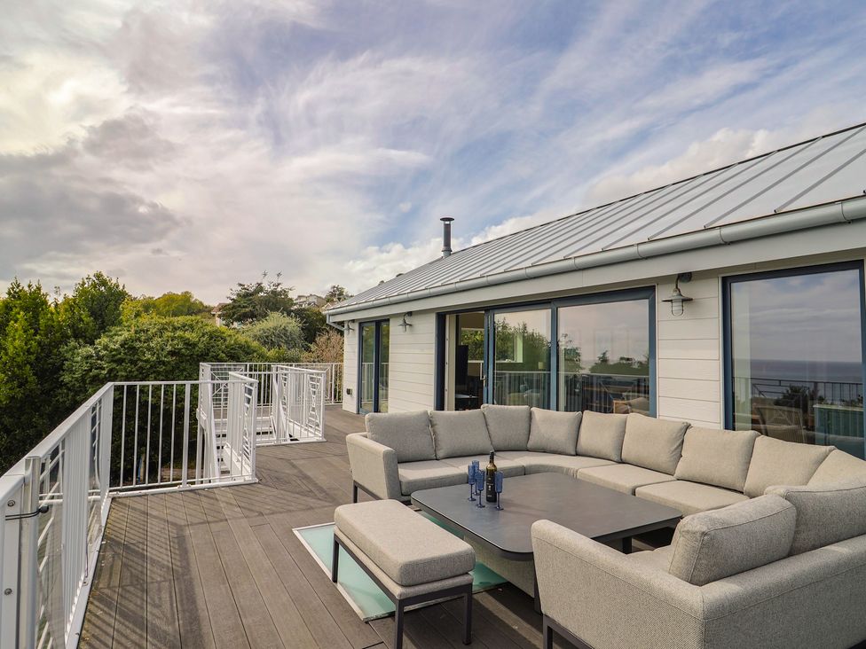 An outdoor seating area with a sectional sofa and table at 13 Downside Close in Charmouth