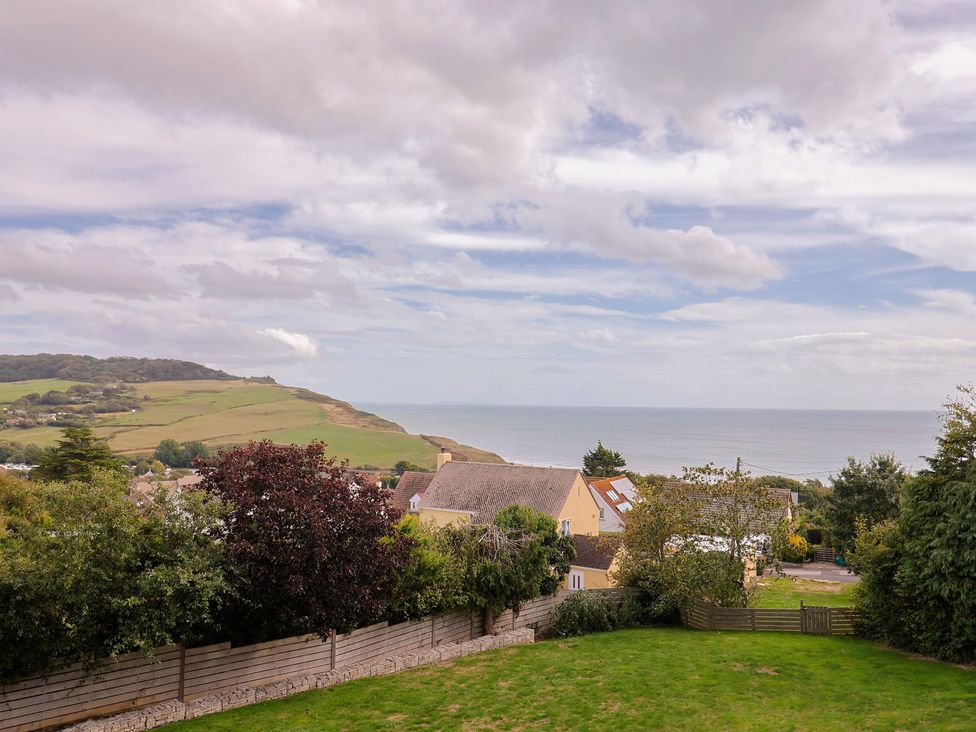 A view of houses and sea from a garden at 13 Downside Close in Charmouth