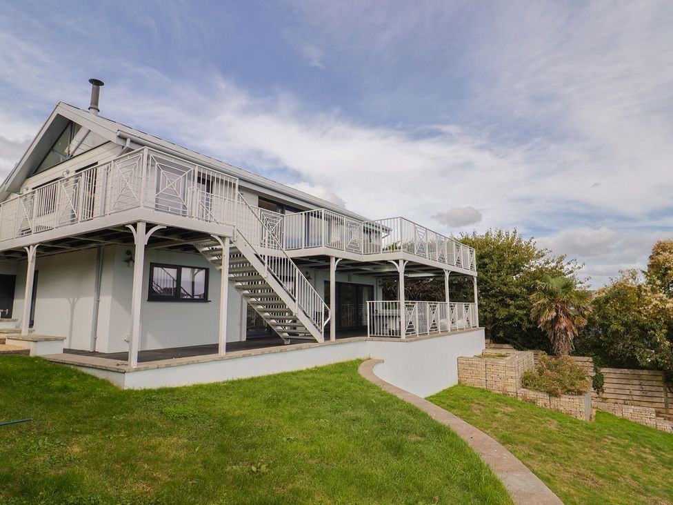 A two-story house with a balcony and garden at 13 Downside Close in Charmouth