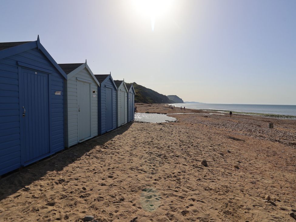 Beach huts along a sandy beach at 13 Downside Close Charmouth