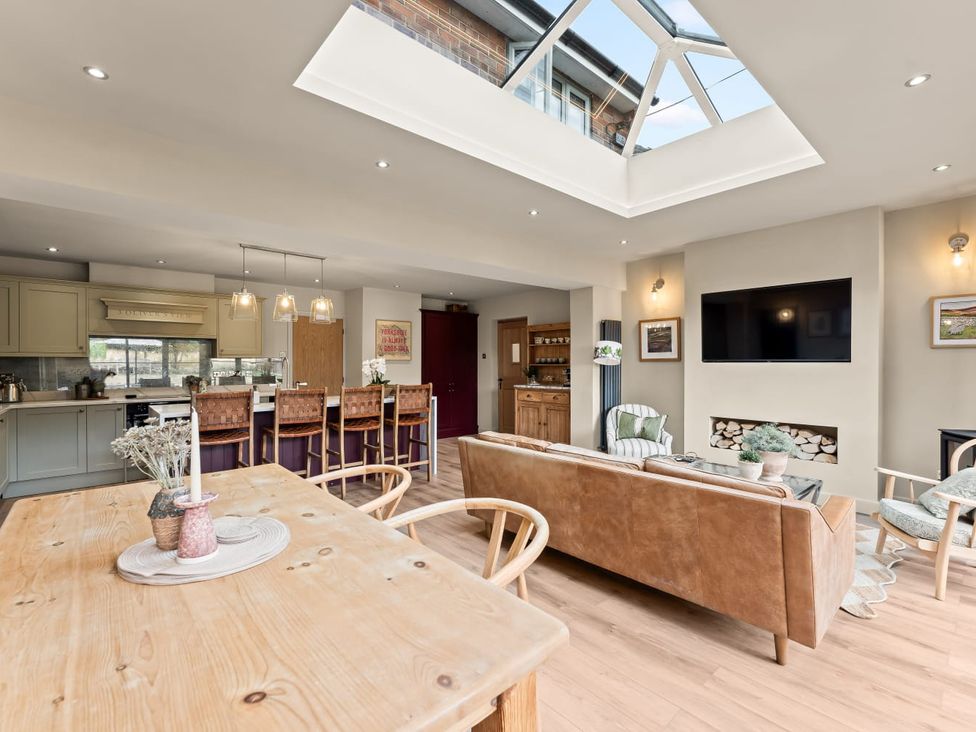 A kitchen with dining table and sofa at 3 Olivers View in Brandsby
