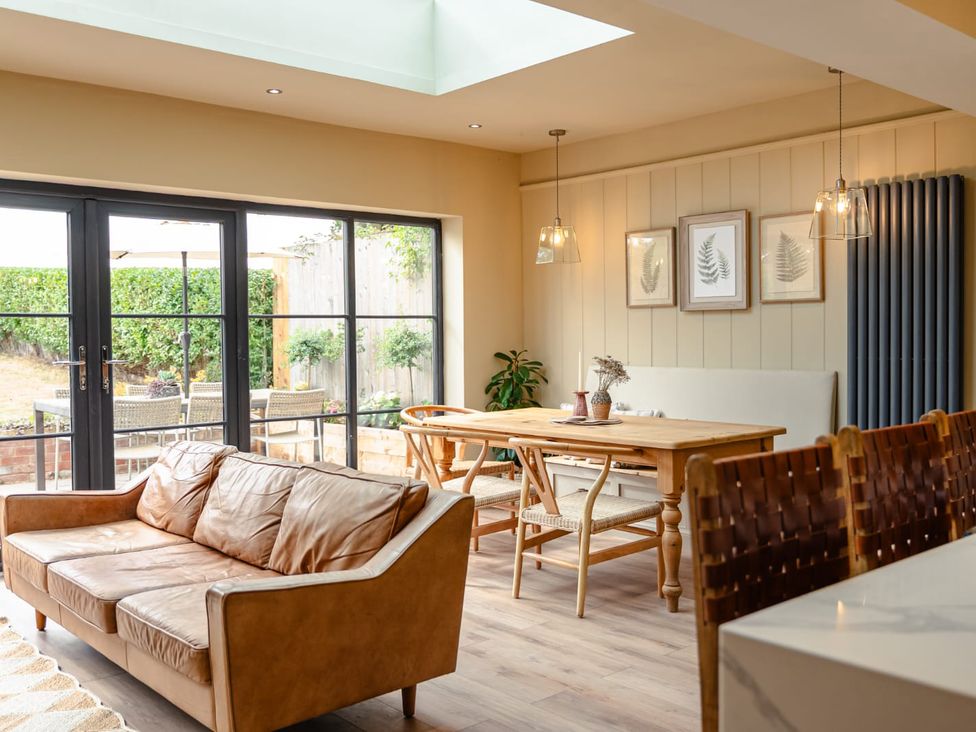 A dining room with a sofa and dining table at 3 Olivers View in Brandsby
