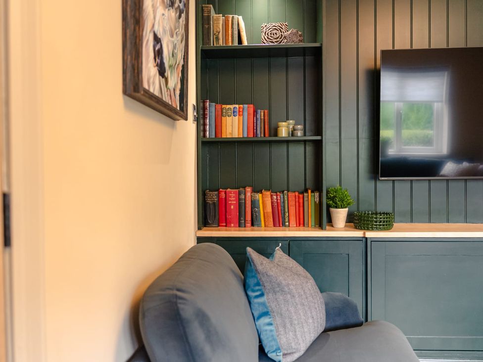 A living room with a sofa and bookshelf at 3 Olivers View in Brandsby