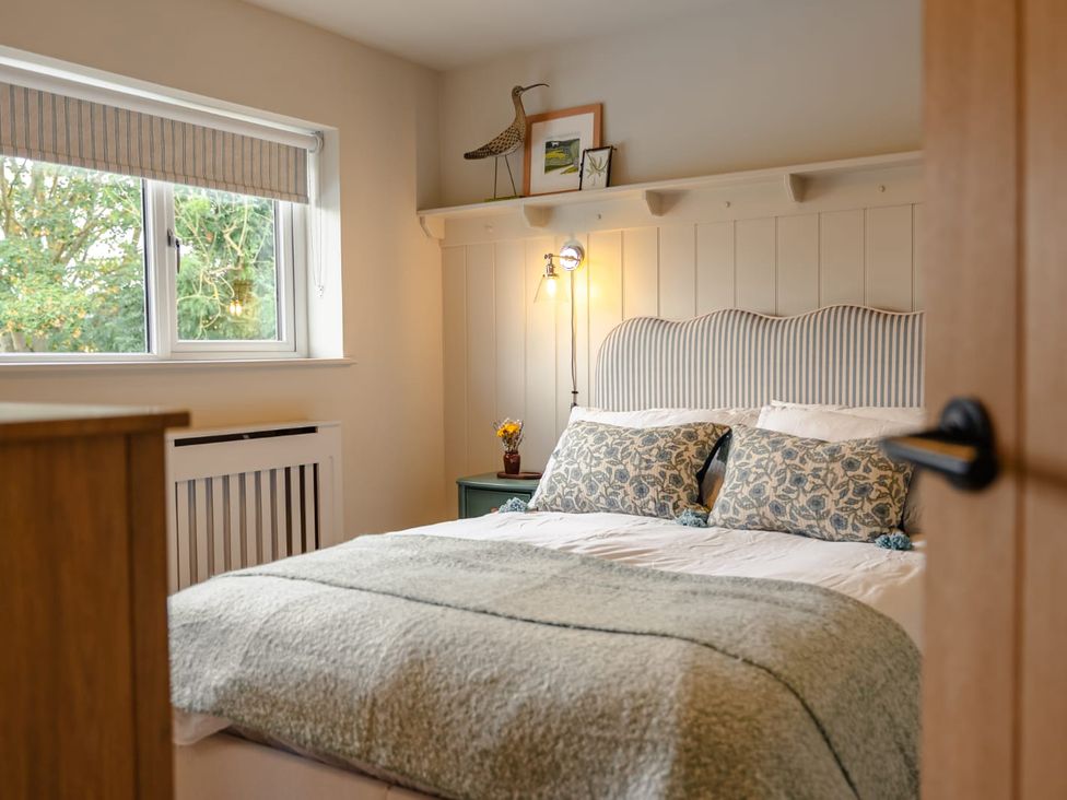 A bedroom with a bed and a bedside table at 3 Olivers View in Brandsby