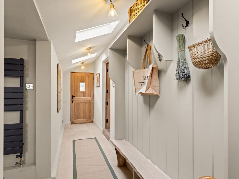 A hallway with a bench and hooks at 3 Olivers View in Brandsby