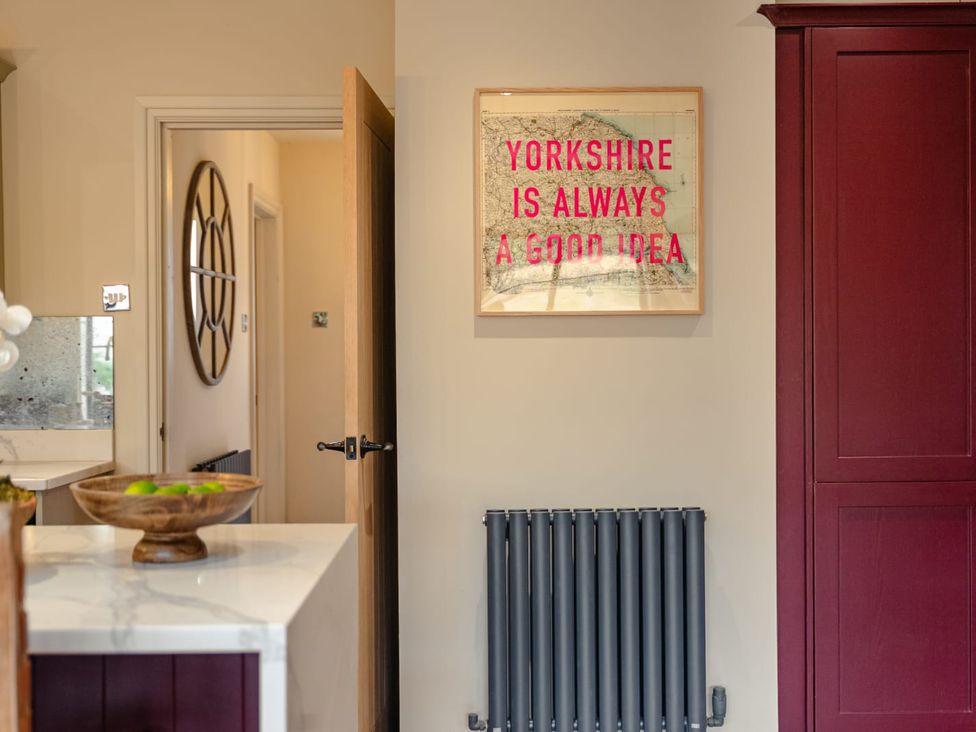 A kitchen area with a door and wall art at 3 Olivers View in Brandsby