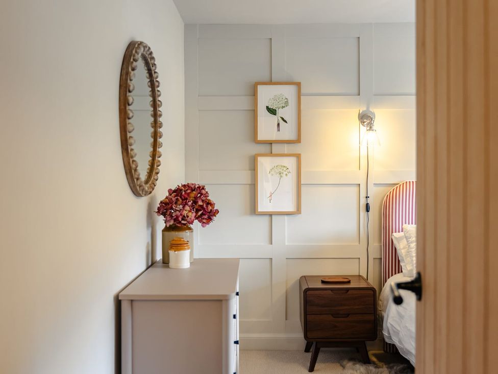 A bedroom with a mirror and framed art at 3 Olivers View in Brandsby