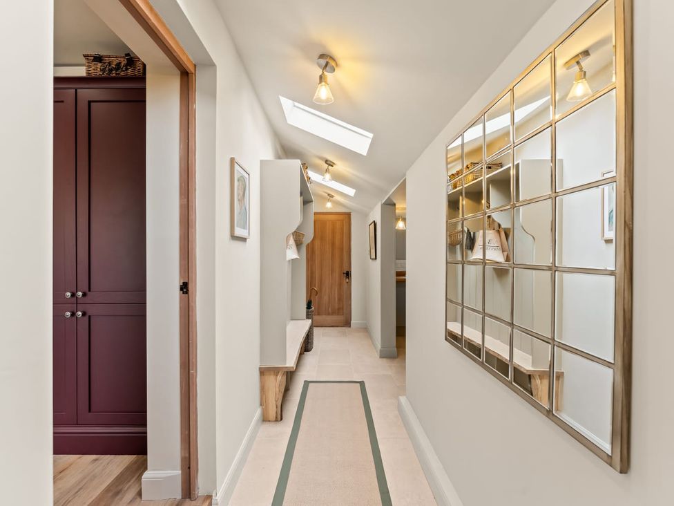 A hallway with a mirror and wooden door at 3 Olivers View in Brandsby