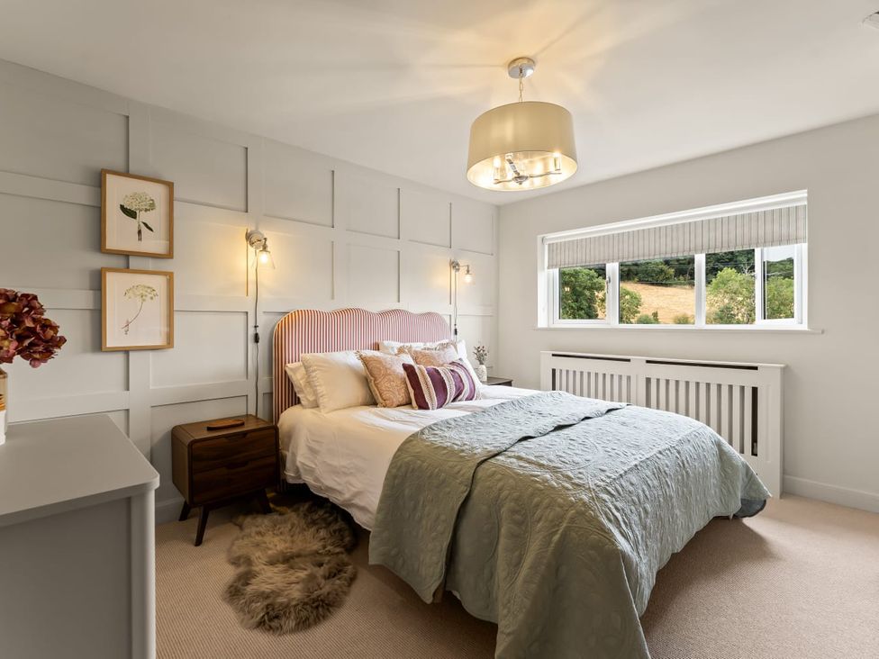 A bedroom with a bed and two lamps at 3 Olivers View in Brandsby