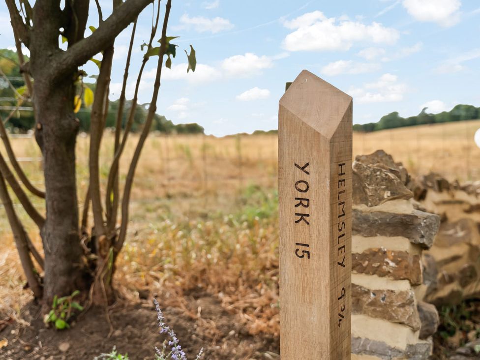 A signpost indicating distances to York and Helmsley in a field