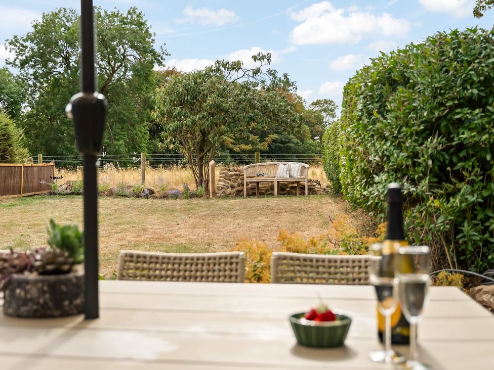 A garden setting with a table and glasses at 3 Olivers View in Brandsby