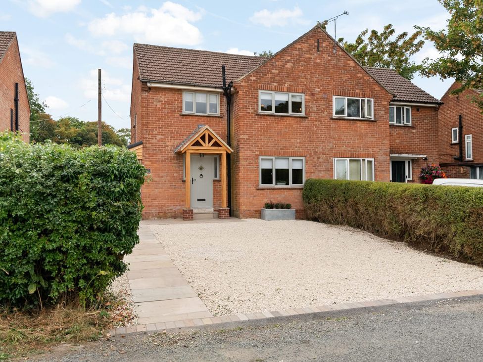 A brick house with a gravel driveway and hedges at 3 Olivers View Brandsby