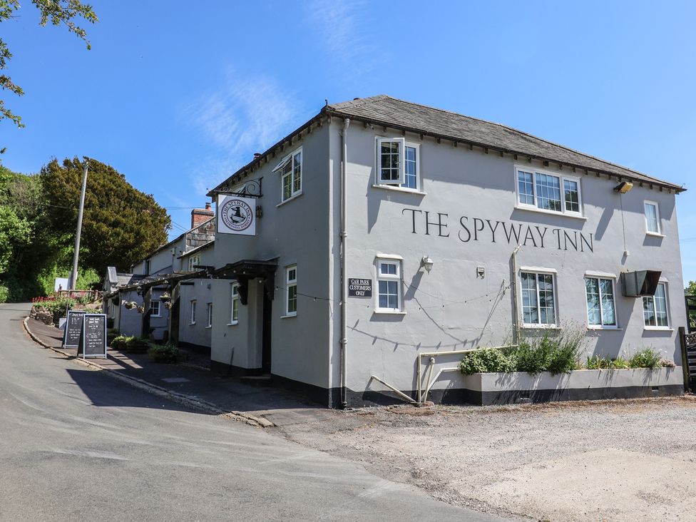 The exterior of The Spyway Inn building with windows and signage on a clear day in a rural area