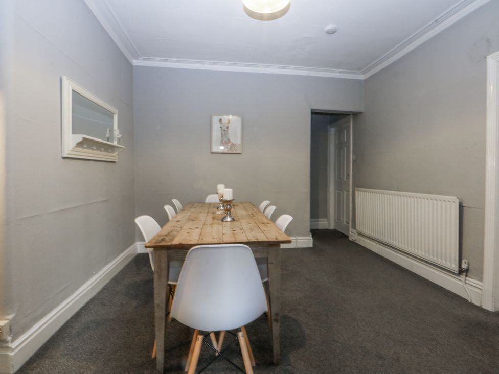 A dining room with a table and chairs at Penrhyn Arms Apartment in Llandudno