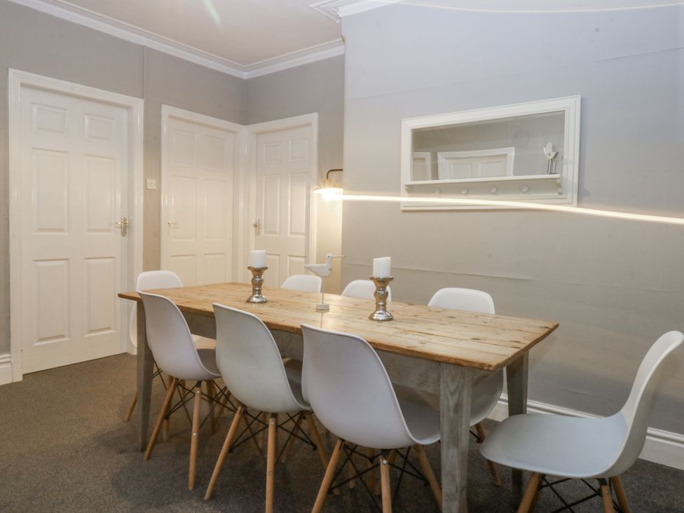 A dining room with a table and chairs at Penrhyn Arms Apartment Llandudno