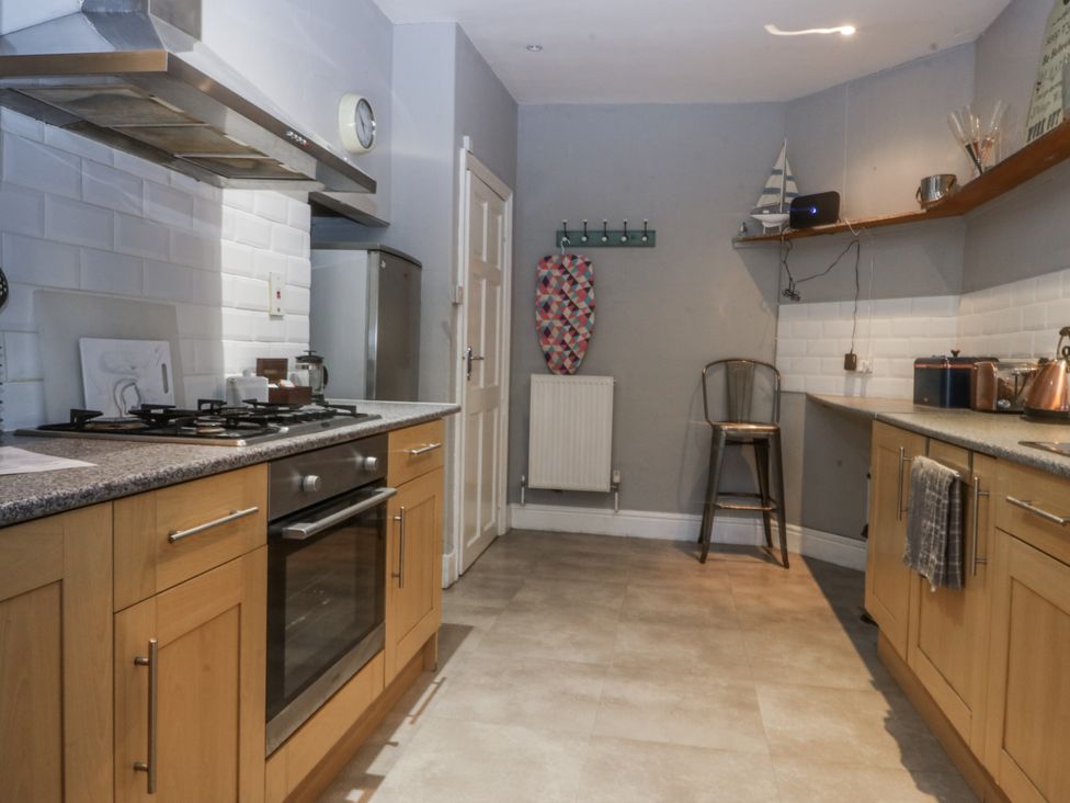 A kitchen with a stove and refrigerator at Penrhyn Arms Apartment Llandudno