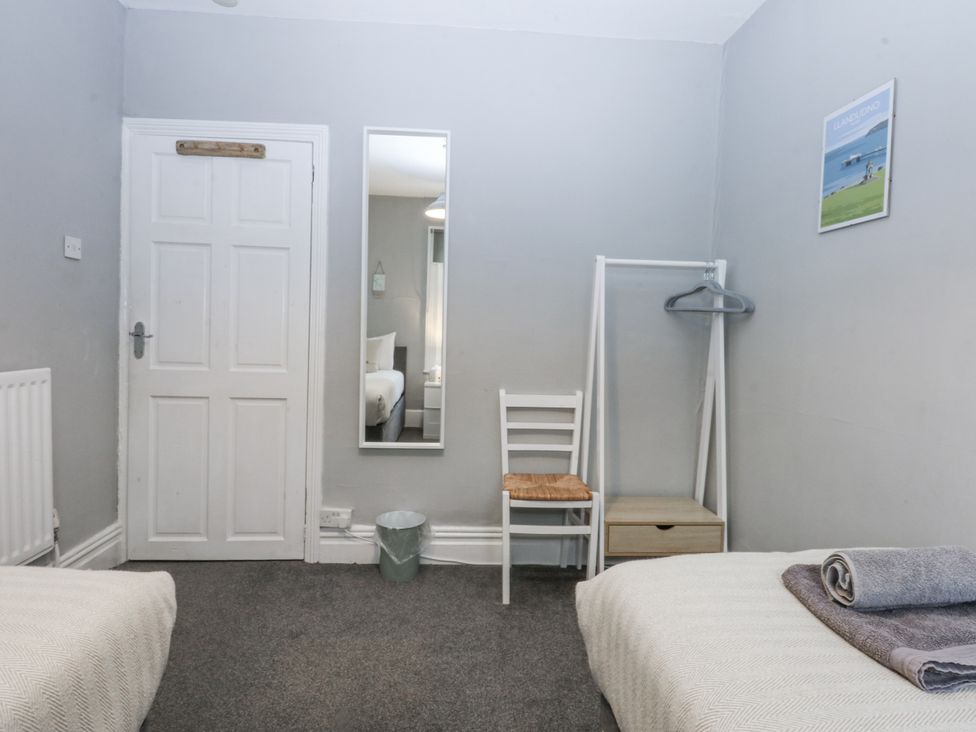 A bedroom with two beds and a mirror at Penrhyn Arms Apartment in Llandudno