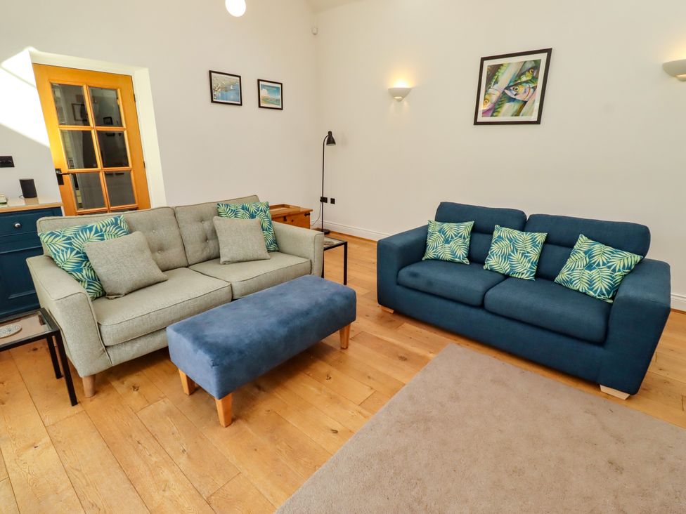 A living room with two sofas and an ottoman at Little Tern in Seahouses