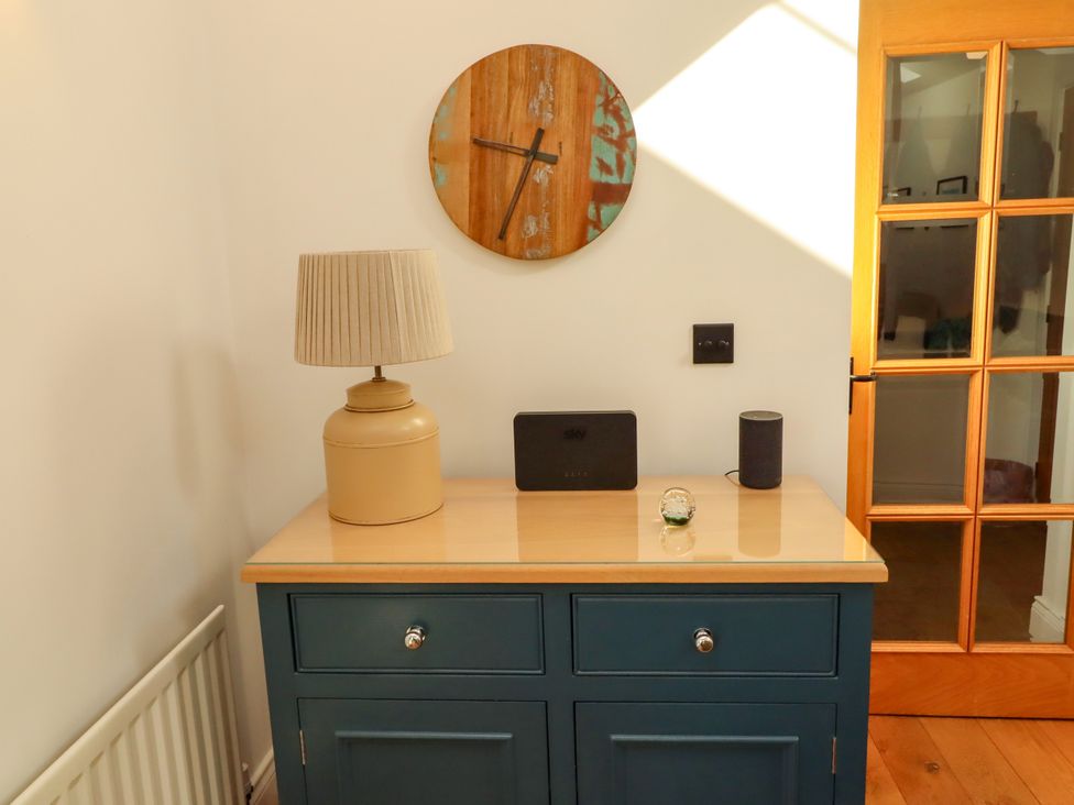 A hallway with a drawer unit and lamp at Little Tern in Seahouses