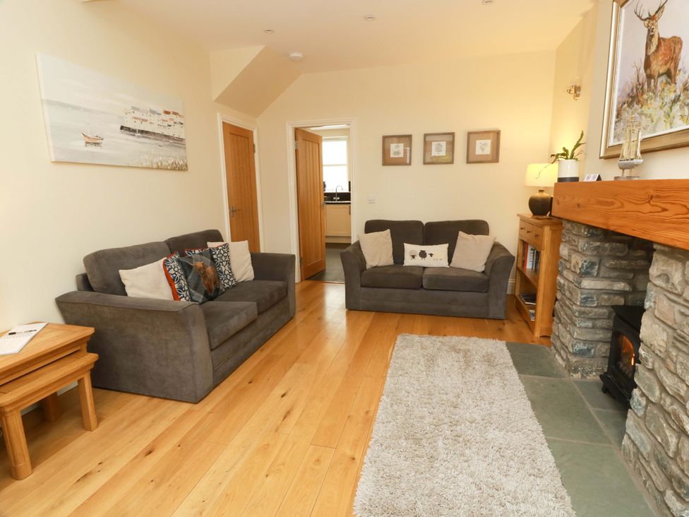 A living room with sofas and a fireplace at Haven Cottage in Kirkcudbright