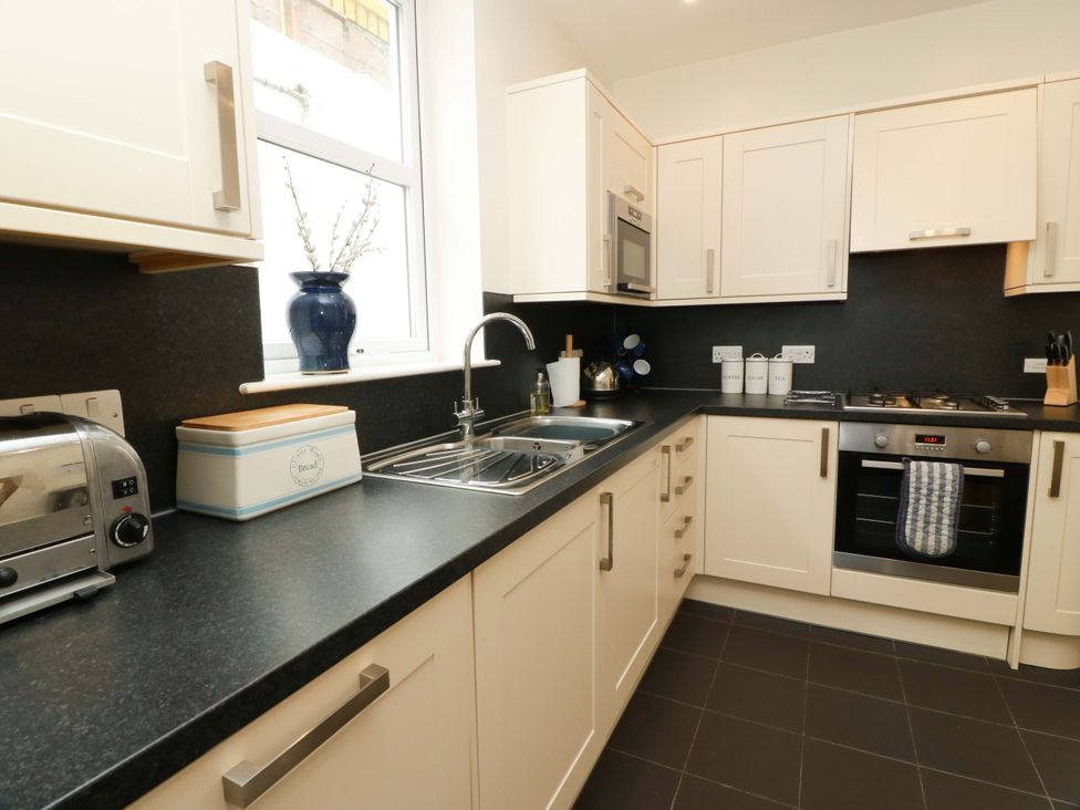 A kitchen with cabinets and appliances at Haven Cottage in Kirkcudbright