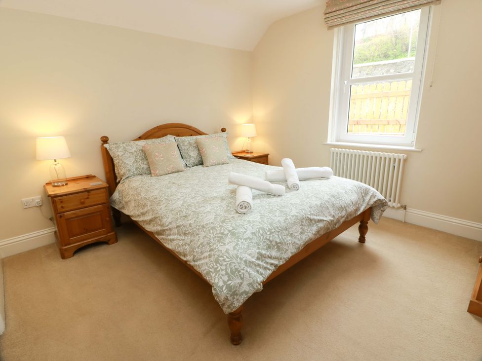A bedroom with a bed and bedside table at Haven Cottage in Kirkcudbright