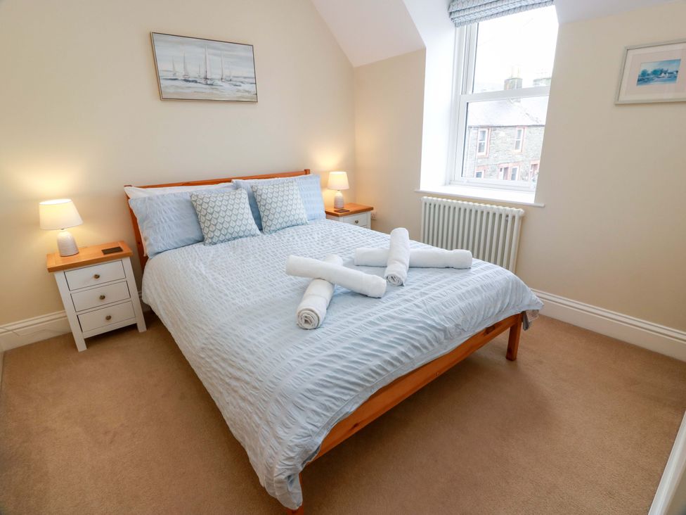 A bedroom with a bed and bedside tables at Haven Cottage Kirkcudbright