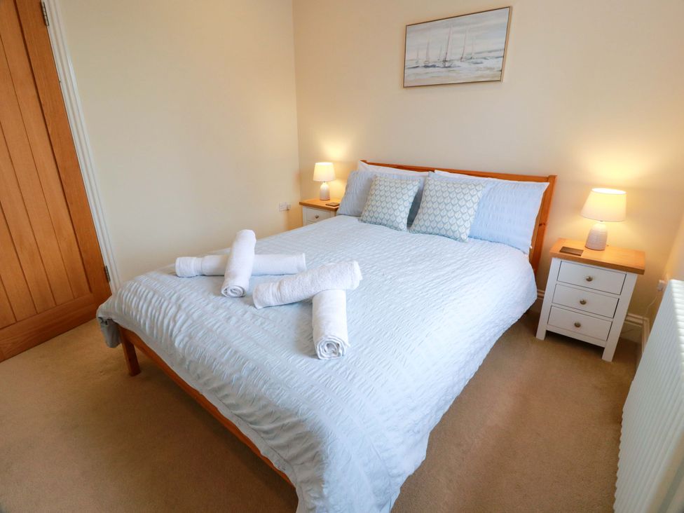 A bedroom with a bed and bedside tables at Haven Cottage Kirkcudbright